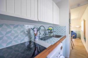 una encimera de cocina con vajilla en un tendedero en Marée Haute et Marée Basse - 1 Appartement et 1 Studio proche de la plage, en Barneville-Carteret 14 fotos más