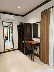 a room with a wooden desk and a mirror at Bang Po Hut in Ban Bang Po