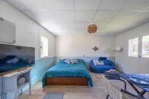 Un dormitorio con una cama, un sofá y una mesa. en Marée Haute et Marée Basse - 1 Appartement et 1 Studio proche de la plage, en Barneville-Carteret