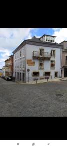 Un gran edificio blanco al costado de una calle. en Apartamento Galería Cine Colón, en Ribadeo
