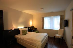 a hotel room with a bed and a window at Art Hotel Lauterbach in Kaiserslautern