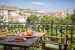 a wooden table with a plate of food on a balcony at Apartments Beata in Marina