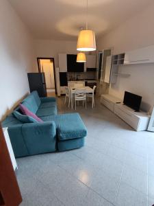 Una sala de estar con un sofá azul y una mesa. en La casetta di Gianni, en Gorleri 3 fotos más