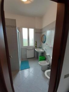 Un baño con dos inodoros, un lavabo y una ducha. en La casetta di Gianni, en Gorleri