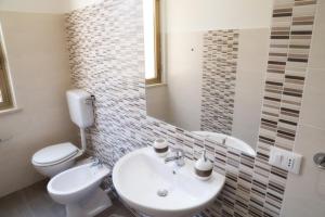 La salle de bains est pourvue d'un lavabo, de toilettes et d'un miroir. dans l'établissement La Bussola, à Trapani