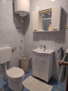 a white bathroom with a toilet and a sink at Planika Apartments 2 in Korčula +23 photos