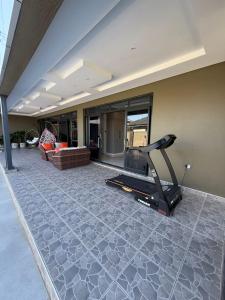 een huis met een fitnessruimte met een bank en een loopband bij Davisons Guest House in Harare