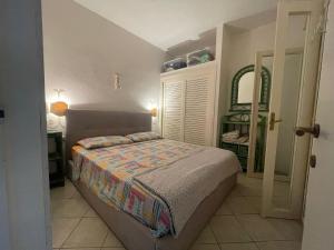 Un dormitorio pequeño con una cama y un espejo. en CasaTobia25, en Costa Paradiso 32 fotos más