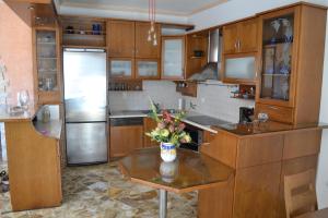 a kitchen with wooden cabinets and a table with flowers on it at Live The Dream in Naxos Chora