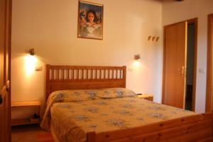 ルチニャーノにあるVilla La Coloniaのベッドルーム1室(ベッド1台付)が備わります。壁に絵が飾られています。