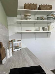 a kitchen with white shelves and a table at Traditional Grandma's house in Chios +25 photos