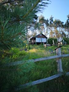 a wooden fence in front of a house at Domek pod lasem podlaskie in Moszczona Pańska