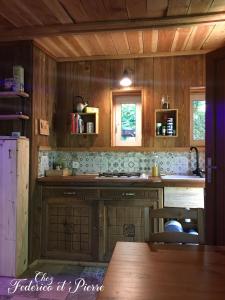 a kitchen with wooden walls and a counter top at Chez Federico et Pierre - La cabane en paille in Le Fraysse