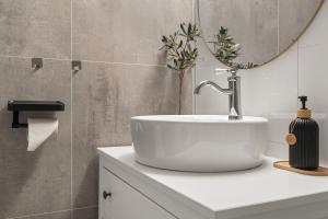 a bathroom with a sink and a mirror at KB - Apartment in Sørvågen +34 photos