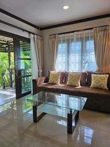 a living room with a couch and a glass table at Bang Po Hut in Ban Bang Po