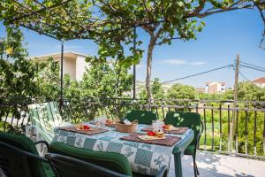 a table with green chairs and a table with food on it at Apartments Beata in Marina