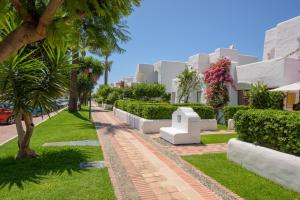 a street with trees and bushes in front of buildings at Casita Villacana in Estepona