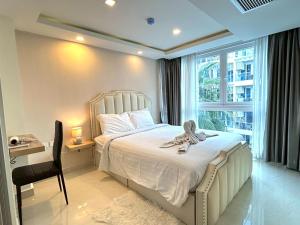 Un dormitorio con una cama y un escritorio y una ventana. en Grand Avenue Residence condominium, en Pattaya central 281 fotos más