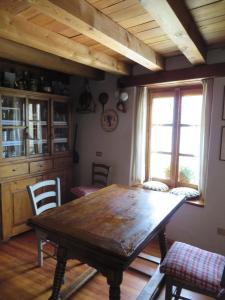 jadalnia z drewnianym stołem i krzesłami w obiekcie Casa Vacanze Roncaiola w mieście Tirano