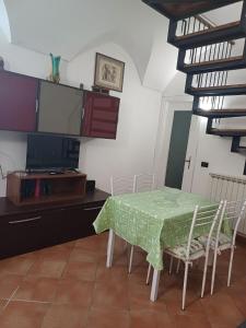 a dining room with a green table and chairs at Portico Ratti in Riva Ligure