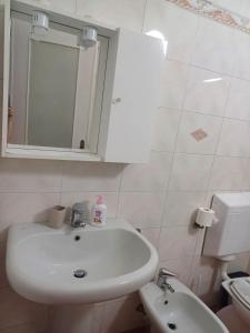 a bathroom with a sink and a mirror and a toilet at Portico Ratti in Riva Ligure