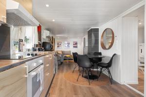 a kitchen with black chairs and a table in it at KB - Apartment in Sørvågen