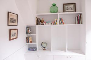 a white book shelf with books and a vase on it at L'air du Large - 150m plage - Confort in Étretat