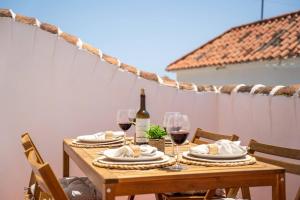einen Holztisch mit Gläsern Wein und Essen in der Unterkunft Picturesque Casita Mijas Pueblo in Mijas + 27 Fotos
