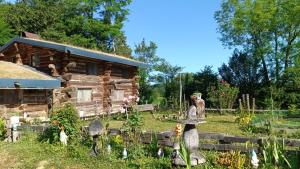 a log cabin with some statues in front of it at chambre d hôtes La cabane du Haouré in Haget