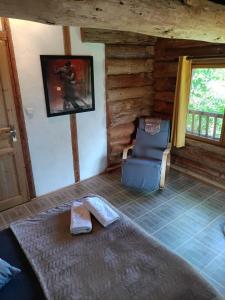 a room with a couch and a chair in a log cabin at chambre d hôtes La cabane du Haouré in Haget