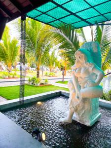 a statue of a girl standing in a pool of water at JKAB Lagoon Resort in Walauttu
