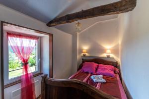 1 dormitorio con cama de madera y ventana en Les Gîtes du Mas Lachamp, en Gravières 116 fotos más
