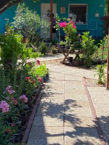 a garden with flowers in front of a house at Arvisura Vendégházak family and pet friendly apartments in Zsombó