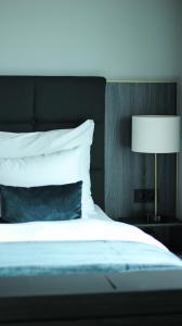 a bed with a blue pillow and a lamp at Clarion Hotel Air in Sola