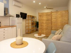 a kitchen and a living room with a couch and a table at Boho Beach Flats in Valencia