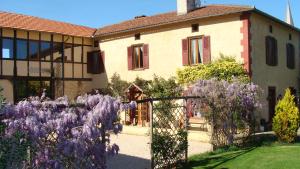 a building with purple flowers in front of it at Gite du Paradis in Vieuzos