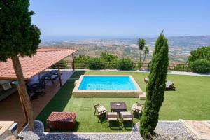 a swimming pool in a yard with a table and chairs at La Casita de mama in Vélez-Málaga