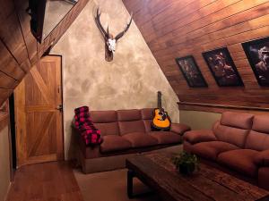 a living room with a couch and a guitar at Rustique Lodge in Nuwara Eliya