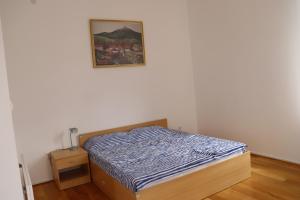 ein Schlafzimmer mit einem Bett und einem Bild an der Wand in der Unterkunft Apartmani "Eliot" in Ilino