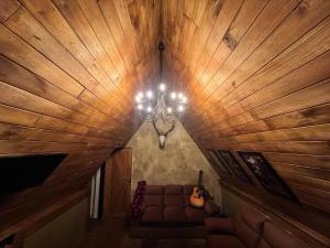 a living room with a couch and a chandelier at Rustique Lodge in Nuwara Eliya