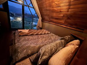 a bed in a room with a large window at Rustique Lodge in Nuwara Eliya