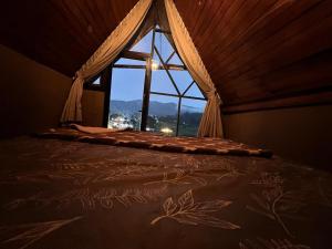a bed in a room with a window at Rustique Lodge in Nuwara Eliya +1 photo