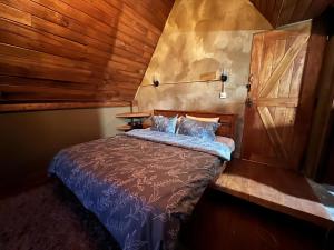 a bedroom with a bed with a wooden wall at Rustique Lodge in Nuwara Eliya