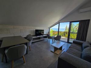 a living room with a couch and a table with chairs at Aura Maris Sutivan in Sutivan