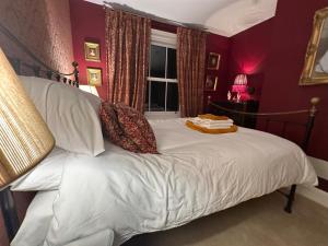 a bedroom with a bed with white sheets and a window at Hitchcock House in Hastings +78 photos