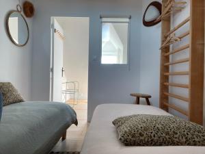 a bedroom with two beds and a stair case at la maison Sel in Audresselles