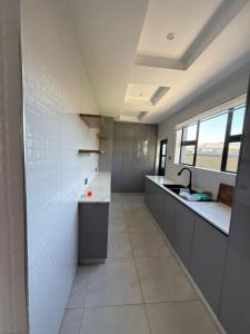 een grote keuken met een wastafel en een aanrecht bij Davisons Guest House in Harare +10 foto's