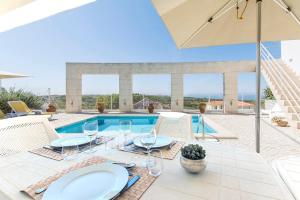 un patio con tavolo e sedie e una piscina di Villa Foz ad Aldeia do Meco