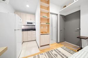 a kitchen with white cabinets and a refrigerator at Corporate Style Studio Near State House in Boston