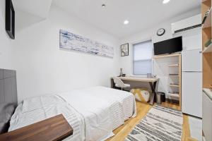 a white bedroom with a bed and a desk at Corporate Style Studio Near State House in Boston